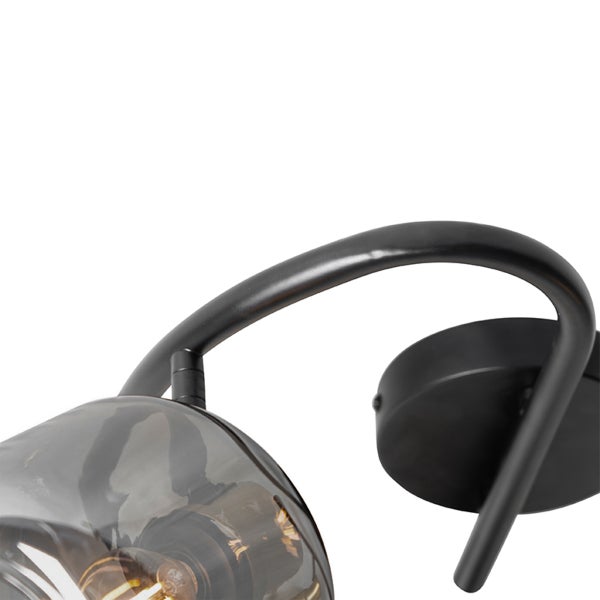 Wandleuchte aus schwarzem Metall mit rauchfarbenem Glasschirm und sichtbarem Leuchtmittel.