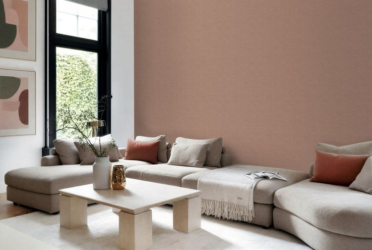 Modernes Wohnzimmer mit strukturierter Tapete in Leinenoptik, großem modularem Sofa und hellem Holztisch.