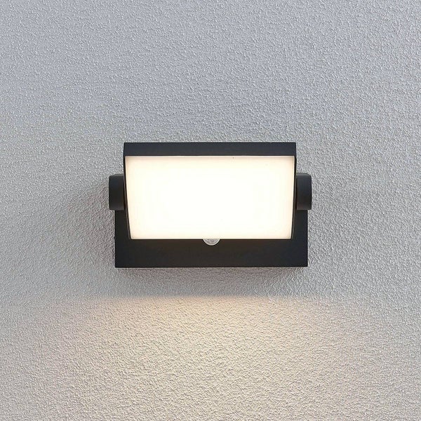 LED Außenwandleuchte in Schwarz, rechteckig, mit Bewegungsmelder, montiert an einer strukturierten Wand.