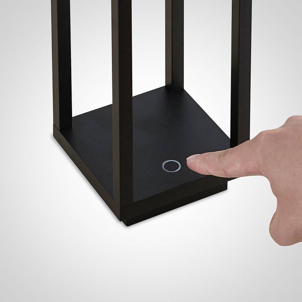 Nahaufnahme einer Leuchte mit Touch-Sensor-Bedienung am Sockel, bei der ein Finger den Schalter betätigt.