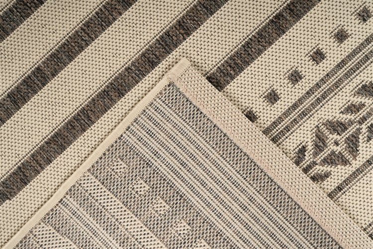 Flachgewebter Teppich mit Streifen und geometrischem Muster, Detailansicht der Webstruktur und der umkettelten Kante.