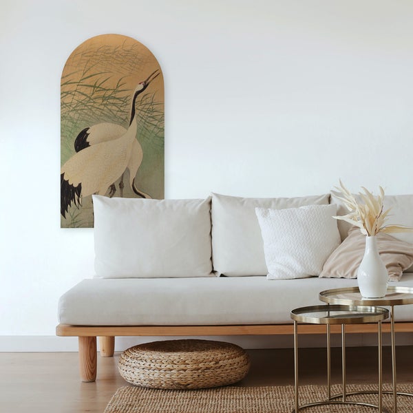 Wohnzimmer mit Sofa, Beistelltischen und Wandkunst mit Kranichmotiv