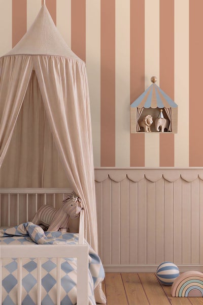 Kinderzimmer mit gestreifter Tapete, gewellter Wandverkleidung, Holz-Kinderbett mit Betthimmel und Wandregal im Zirkus-Design.