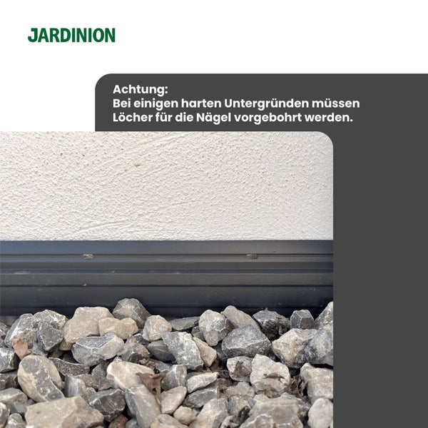 JARDINION Logo. Hinweis: Bei harten Untergründen Löcher für Nägel vorbohren. Schwarzes Profil an weißer Wand über grauem Kies.