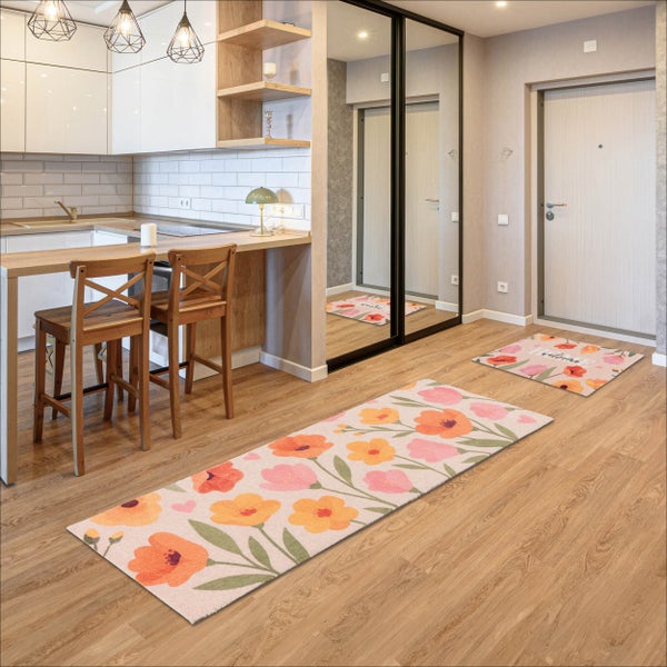 Moderner Flur und Küchenbereich mit floralen Läufern und Fußmatte auf Holzboden, mit Holzbarhockern und weißen Schränken.