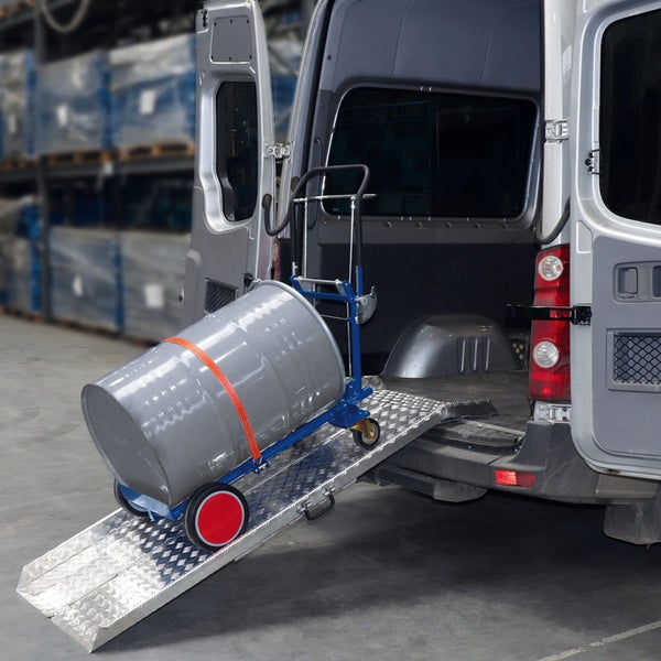 Eine silberne Aluminium-Verladerampe ist am Heck eines Transporters angebracht. Eine Sackkarre transportiert ein Fass über die Rampe ins Fahrzeug.
