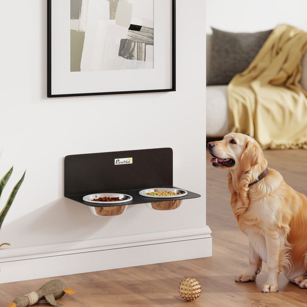 Wandmontierte Hundebar aus schwarzem Metall mit zwei Edelstahlnäpfen, einem goldenen Retriever in einem hellen Wohnzimmer und PawHut Logo.