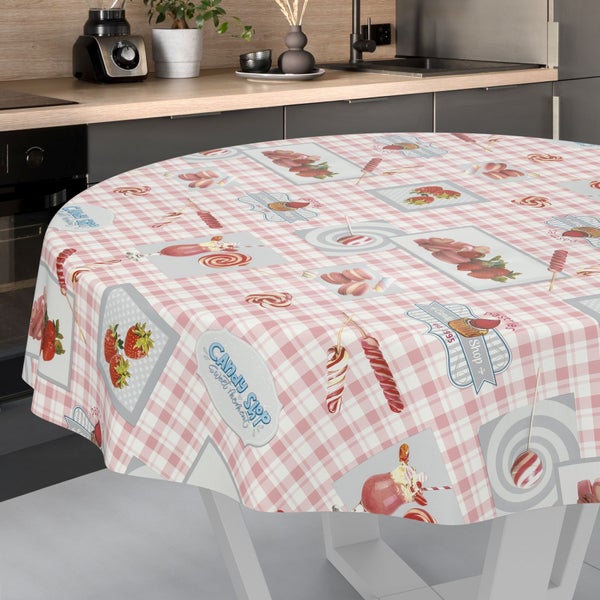 Runde Tischdecke mit Karomuster und Süßigkeiten-Motiven wie Erdbeeren und Macarons in einer hellen, modernen Küche.