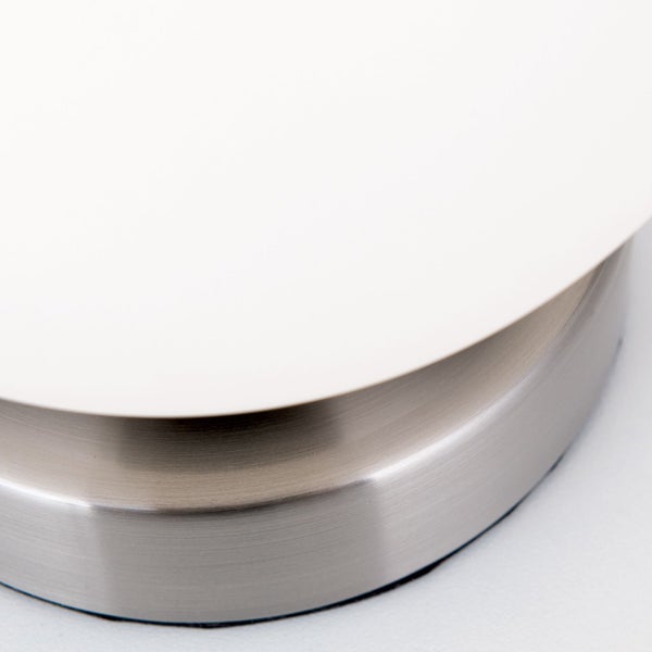 Detailaufnahme einer Tischleuchte mit Metallfuß und Lampenschirm