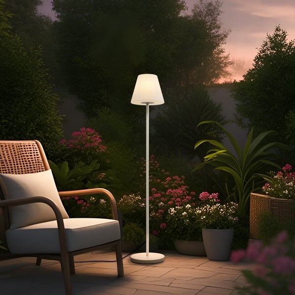 Moderne Stehleuchte für den Außenbereich auf einer Terrasse neben einem Gartenstuhl bei Dämmerung.