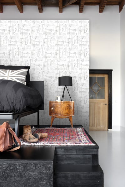 Schlafzimmer mit Bett, Nachttischlampe und Flugzeugmuster-Tapete