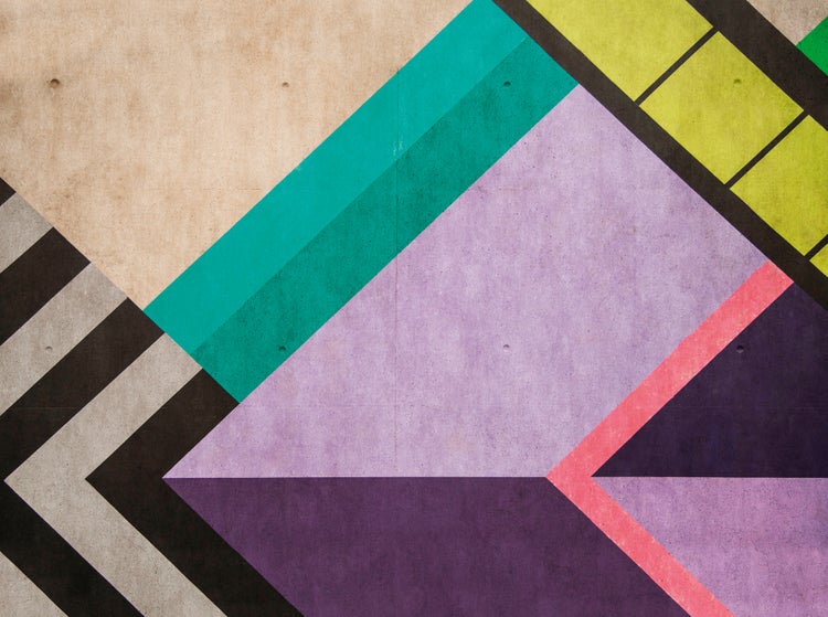 Wandgestaltung mit geometrischem Muster aus Dreiecken und Streifen auf einer Oberfläche in Betonoptik.