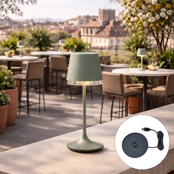 Moderne grüne LED-Außentischleuchte auf einer hellen, organisierten Terrasse mit Tischen und Stühlen, im Detail eine Ladestation mit USB-Kabel.