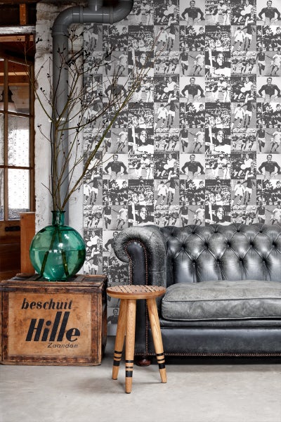 Wohnzimmer mit Ledersofa, Holzhocker, Holzkiste und Fototapete