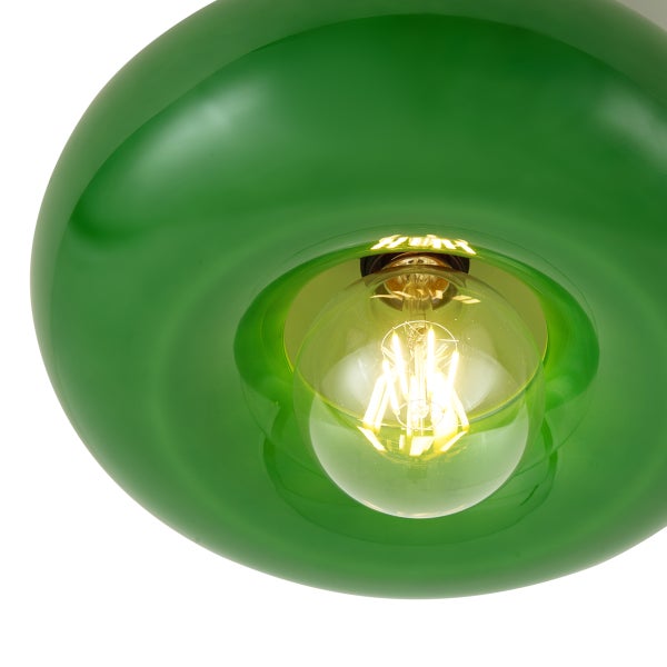 Nahaufnahme eines grünen, runden Lampenschirms aus Glas mit einem leuchtenden Filament-Leuchtmittel.