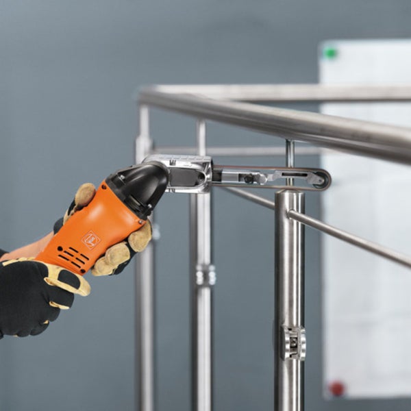 Fein Multitool mit Bandschleifvorsatz bearbeitet ein Edelstahlgeländer.