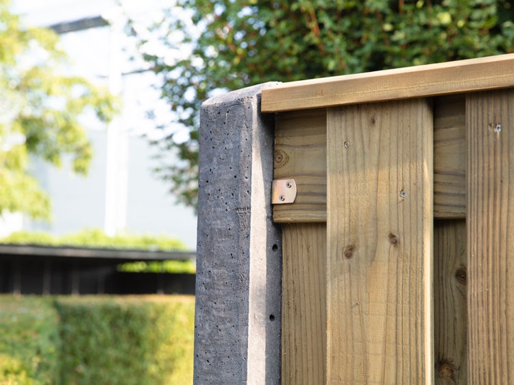 Detailansicht eines Gartenzauns mit Betonpfosten und Holzbrettern