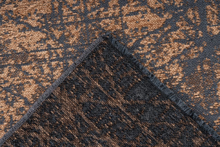 Teppich mit abstraktem Muster, gewebter Struktur und umgeschlagener Ecke, die die Rückseite und die gekettelte Kante zeigt.