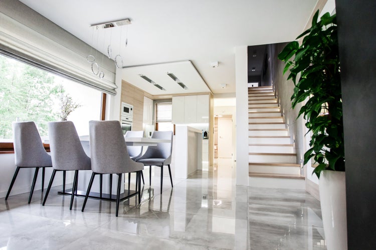 Heller Wohnraum mit Esstisch, Stühlen und Treppe