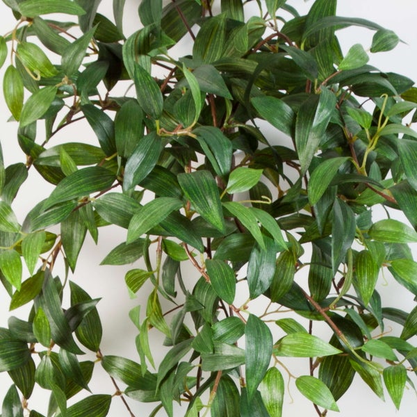 Künstliche Hängepflanze mit grünen Blättern in kaskadierender Form.
