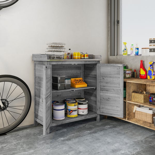 Werkstattschrank in Grau mit Holzoptik, zwei Türen, befüllt mit Farbeimern und Werkzeugboxen in einer aufgeräumten Garage.