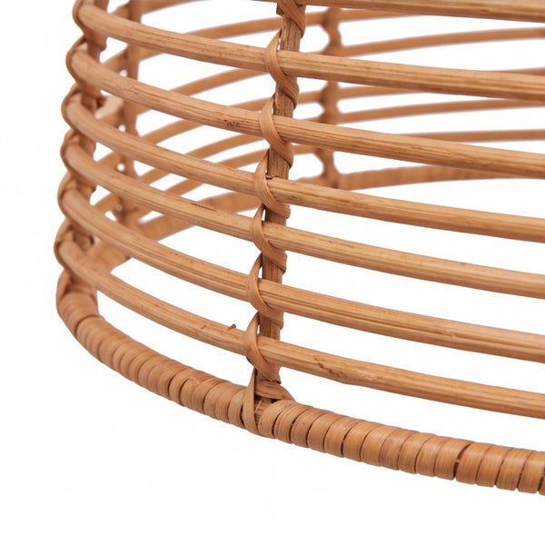 Detailaufnahme eines geflochtenen Lampenschirms aus Rattan mit runder Gitterstruktur.