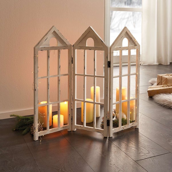 Dekorativer Raumteiler im Fensterdesign mit Kerzen und Lichterkette für eine stimmungsvolle Atmosphäre.