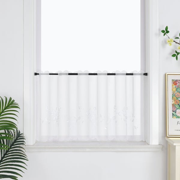 Gardinenstore mit Blumenmuster vor einem Fenster