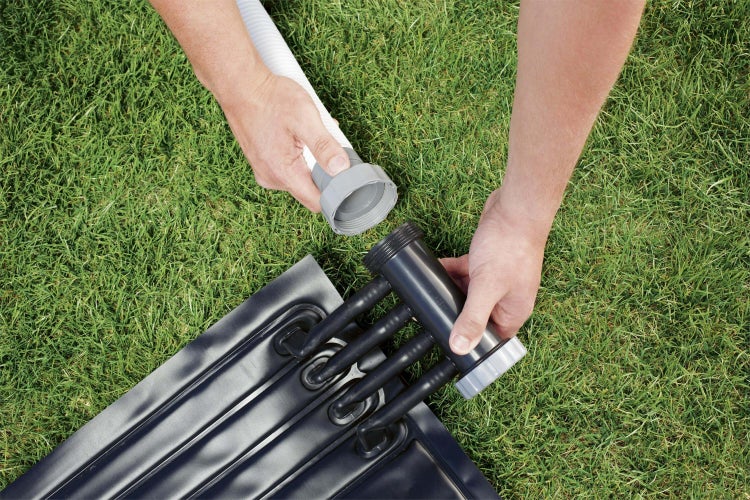 Installation eines Poolsolarabsorbers mit Schlauchverbindung auf Rasen