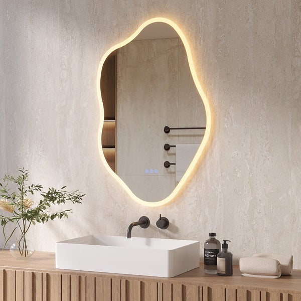 Organisch geformter Badezimmerspiegel mit integrierter LED Beleuchtung und Touch Steuerung über einem Aufsatzwaschbecken im modernen Badezimmer