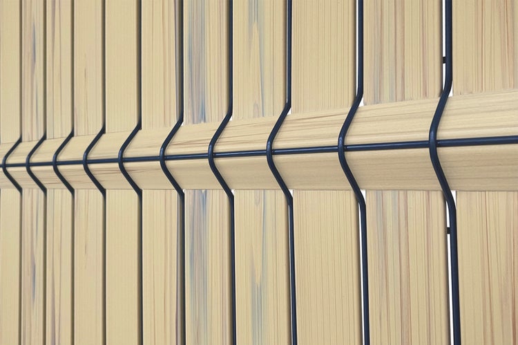 Detailansicht eines Zaunelements mit Holzfüllung und Metallgitter