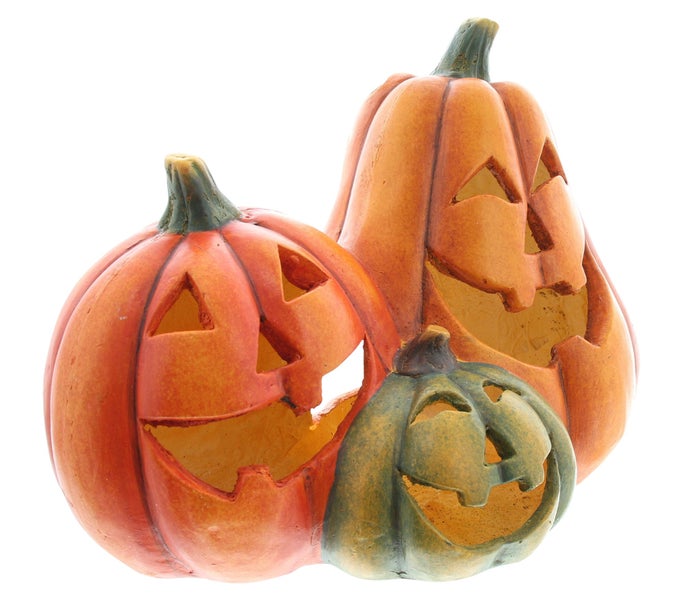 Halloween-Dekoration mit drei Kürbissen mit geschnitzten Gesichtern