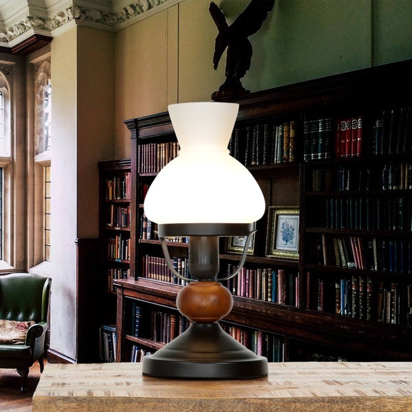 Tischleuchte mit Lampenschirm aus Glas vor Bücherregal