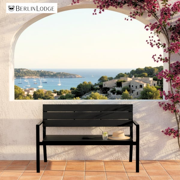 Berlin Lodge Logo. Schwarze Gartenbank aus Metall mit Latten-Design auf einer Terrasse mit Meerblick und mediterraner Bepflanzung.