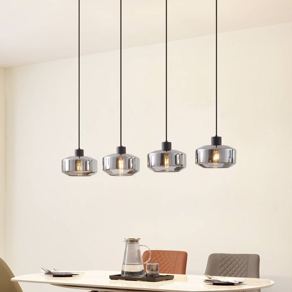 Vierflammige Pendelleuchte mit rauchgrauen Glasschirmen in modernem Design über einem hellen Esstisch.