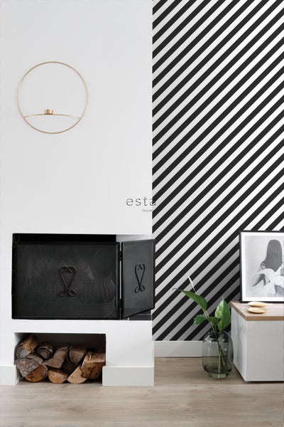 Wohnraum mit Kamin, Holzscheiten, Zimmerpflanze und grafischer Tapete