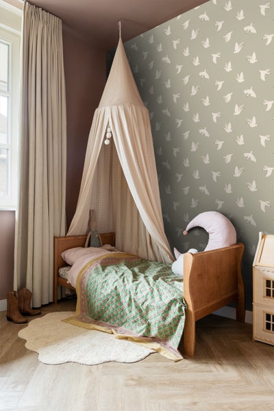 Helles Kinderzimmer mit Bett, Baldachin, gemusterter Tapete und dekorativen Elementen