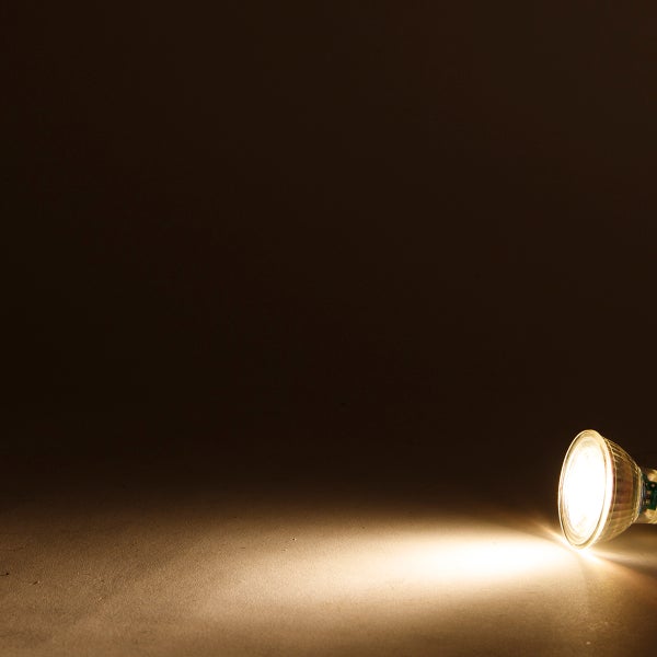 Eingeschaltete LED-Reflektorlampe mit warmweißem Lichtkegel.