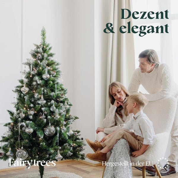 Eine Familie betrachtet einen geschmückten FairyTrees Weihnachtsbaum mit Kunstschnee in einem hellen, wohnlichen Raum.