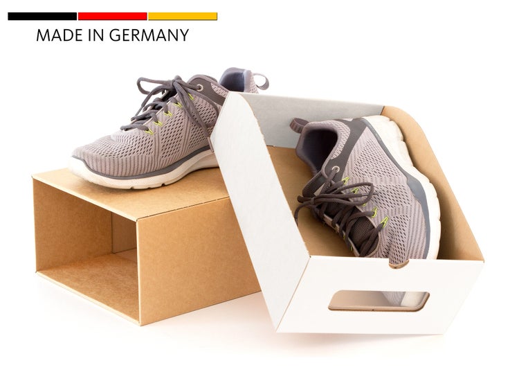 Ein Paar Sportschuhe mit Schnürung in einer zweiteiligen Pappschachtel mit Made in Germany Kennzeichnung.