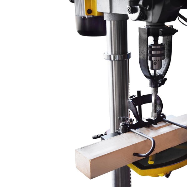 Standbohrmaschine beim Bohren eines Holzstücks.