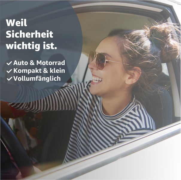 Eine Frau sitzt in einem Auto und lächelt.