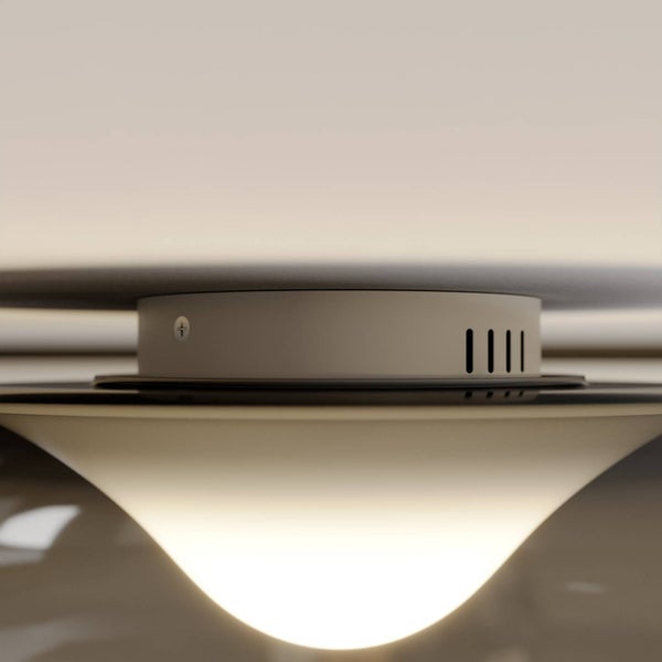 Nahaufnahme einer modernen Deckenleuchte mit zylindrischer Halterung und geschwungenem beleuchtetem Schirm.