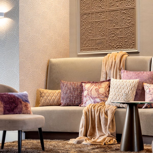 Wohnzimmer mit Sofa, Kissen, Decken, Stuhl und Wanddekoration