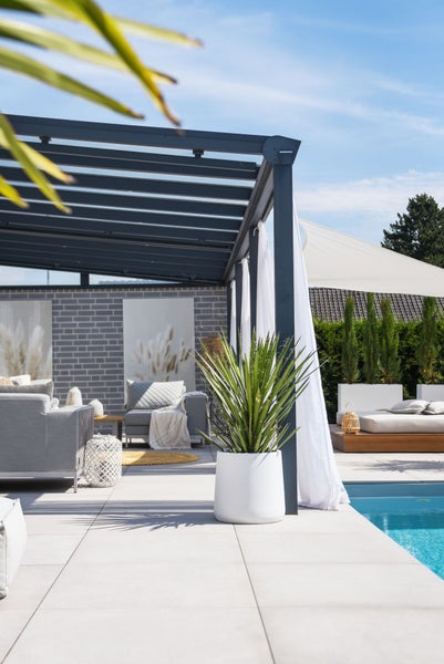 Moderne Terrasse mit anthrazitfarbenem Terrassendach, Pool, hellgrauen Gartenmöbeln, weißem Pflanzkübel und Sonnensegel.