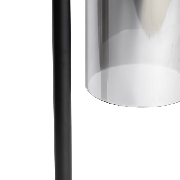 Detailaufnahme einer Stehlampe mit transparentem Schirm und dunklem Lampenfuß.