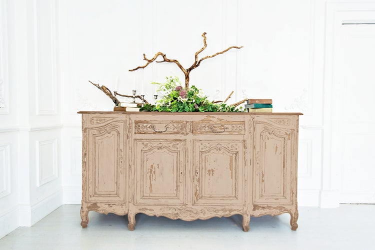 Buffetschrank im Vintage-Stil mit floraler Dekoration und Büchern