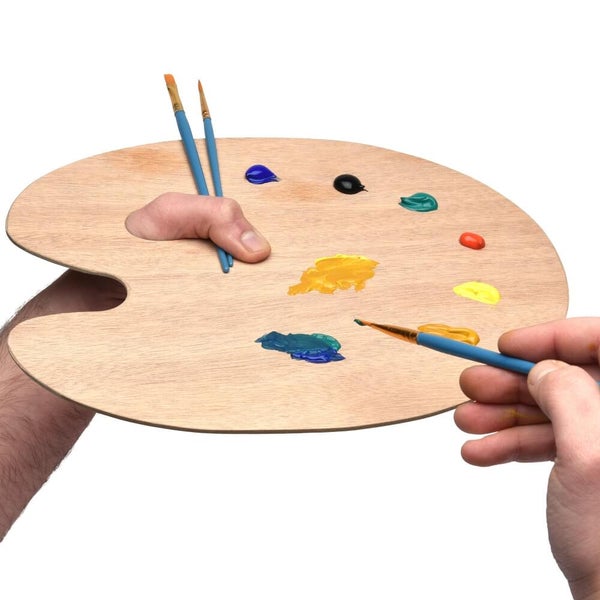 Holzpalette mit Farbtupfern und Pinsel in der Hand