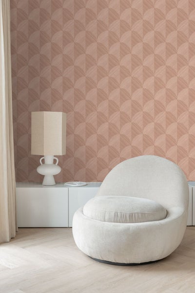 Vliestapete mit geometrischem Fächermuster und feiner Linienstruktur in einem modernen Wohnraum mit Sessel, Tischlampe und Sideboard.