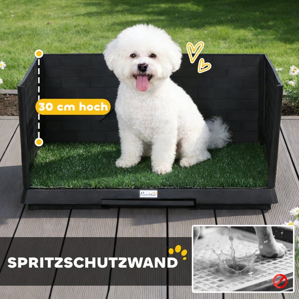PawHut Hundetoilette mit 30 Zentimeter hoher Spritzschutzwand und Kunstrasen, weißer Hund sitzt darin auf einer Holzterrasse.